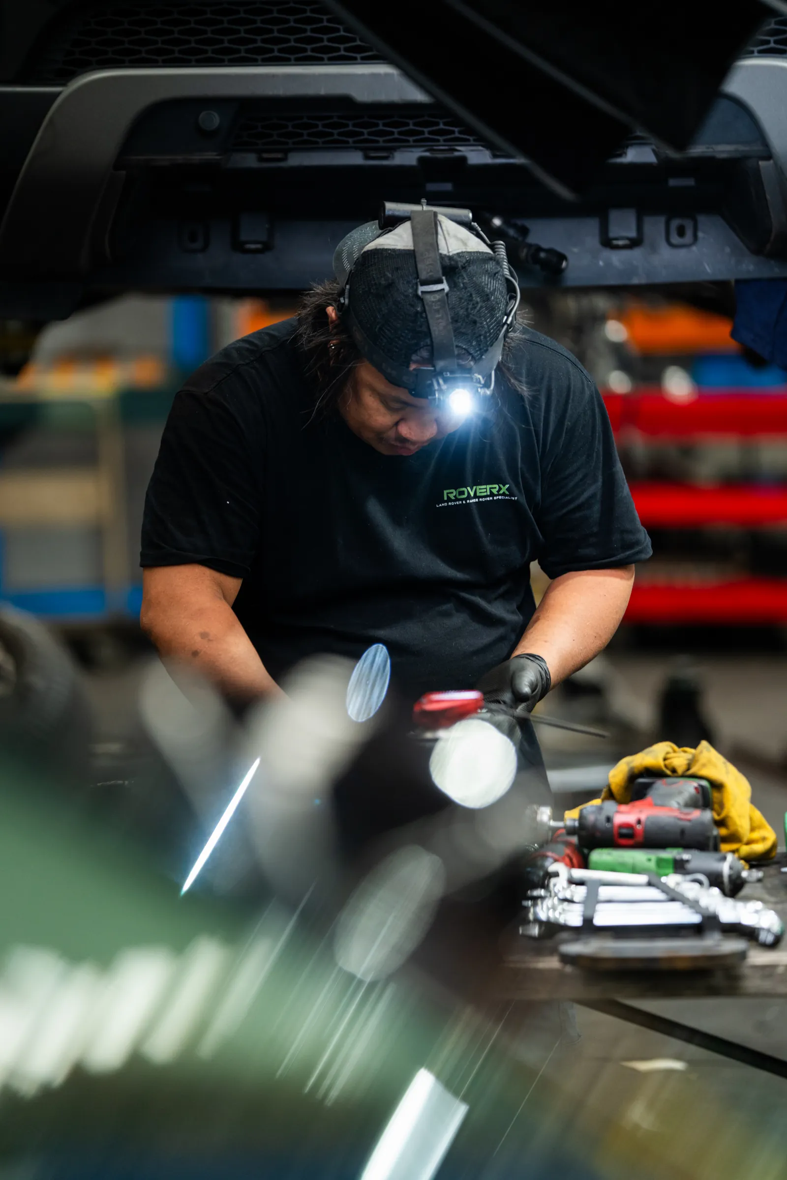 RoverX technician tracing an auto electrical fault under the bonnet