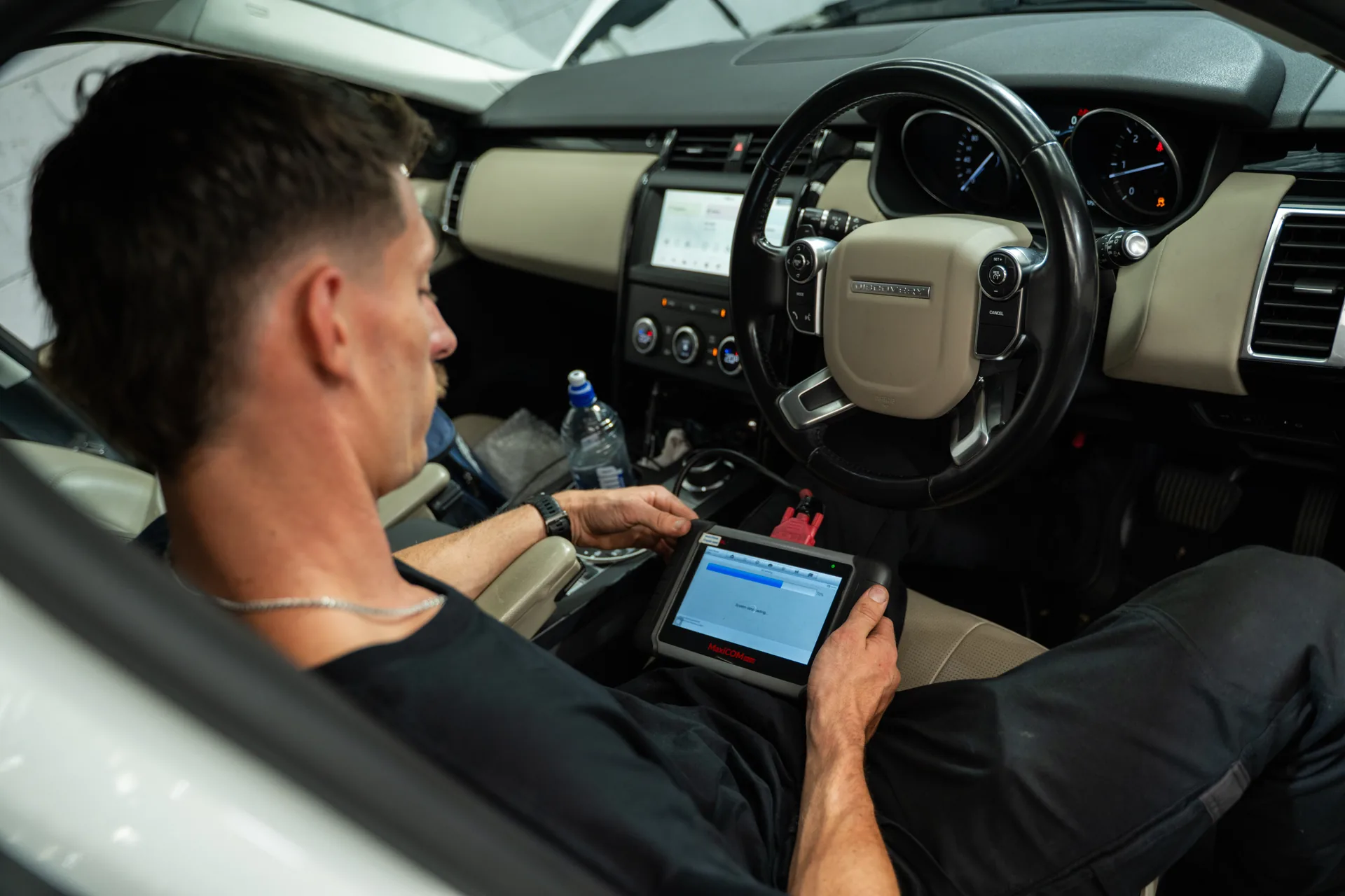 RoverX technician running JLR diagnostics inside a Range Rover